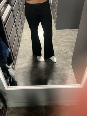 Svarta kostymbyxor med rak passform - Säljer ett par svarta kostymbyxor med rak passform och låg midja. Byxorna har en klassisk look och är perfekta till en snygg outfit. Materialet är mjukt och följsamt, vilket ger en skön känsla. Passar dig som gillar stilrena och tidlösa plagg.