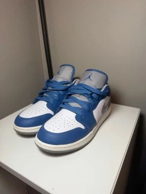 Air Jordan 1 Low True Blue - Säljer ett par Air Jordan 1 Low True Blue. Använda ca 2 ggr men fortfarande i mycket fint skick med litet slitage och lite smuts på sulorna (kan rengöras). Bekväma sneakers som passar till det mesta och en klassisk färgkombination. Skick enligt bilder. Hör av dig om du vill ha fler bilder eller har frågor. Kartong medföljer ej.