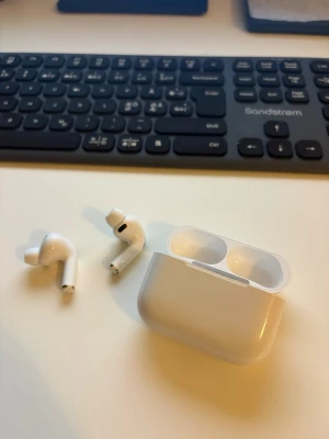 AirPods Pro 3 - Säljer ett par AirPods Pro 3 med tillhörande laddningsetui. Hörlurarna har en stilren och kompakt design med silikonproppari för bättre passform. Perfekta för musik, poddar och samtal på språng. Kartongen finns inte kvar, och kvittot finns vid behov