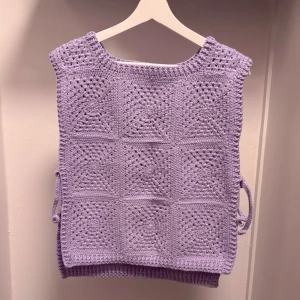Lilac Crochet Vest - Handmade Crochet Granny Square Vest 60's vintage-style crochet vest featuring lilac granny squares. Made with soft yarn. Ties on the sides for an adjustable fit. Perfect layered over a t-shirt or dress for that cozy, boho look. Size: One size (fits S-M best) Condition: New/unused