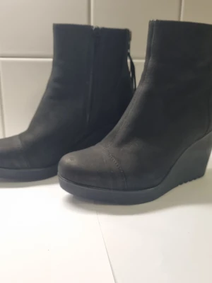 Vagabond valencia Kilklacksstövletter - Ett par svarta skinn stövletter med kilklack, (Wedge). Stövlarna har dragkedja på insidan och en liten dekorativ tofs baktill. Modellen är Valencia Skorna är i mycket bra skick med minimala tecken på slitage.
