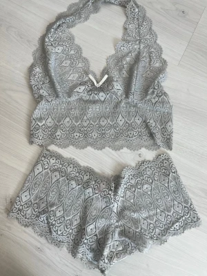 Vintage Victoria Secret set - Säljer ett superfint vintage grått spetsset från Victoria Secret. Setet har ett detaljerat spetsmönster och vågiga kanter som ger en romantisk vibe. Materialet är mjukt och stretchigt för extra komfort. Perfekt för dig som vill ha något både snyggt och bekvämt.