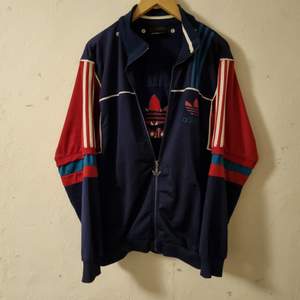 häftigt vintage Adidas jumper i bra skick, köpt på second hand. fungerande dragkedjor och inga trasiga sömmar, märks att den inte är helt ny men inga fläckar eller andra defekter. oversized och mysig att använda. 46cm bred i axlar och 72cm lång