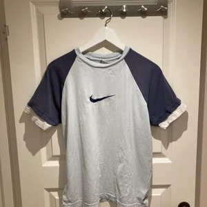 Nike tröja - Fin blå Nike T-shirt! Tror det är barnstorlek L men osäker.. sitter hursomhelst som typ S/M! I fint använt skick, har en fläck på ärmen som bilden visar. Tröjan är ljusblå o mörkblå!