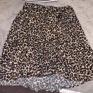 Leopard kjol - En leopard kjol i mycket fint skick. Kjolen går omlott och man kan spänna åt dne i midjan som man kan se på andra bilden. Kjolen är köpt på Lindex. Kjolen är i strl 128 men passar mig som är en strl s