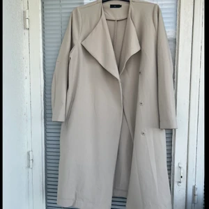 Kappa/Trench coat - Beige, knappt använd, trenchcoat i strl 38 säljes. Trench coaten är i fint skick, har endast en liten fläck (se sista bilden!). Säljes på grund av flytt. 