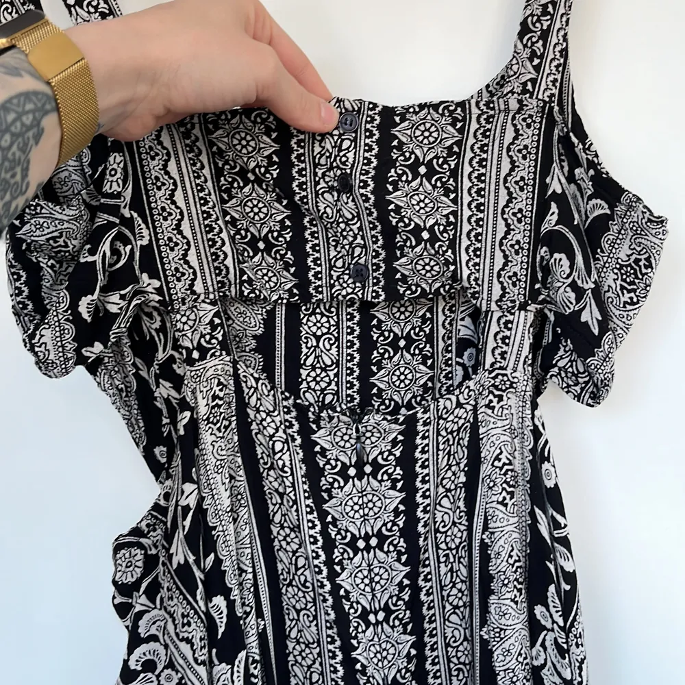 En fin och lätt sommarklänning med boho mönster och cut outs vid midjan.. Mekot.