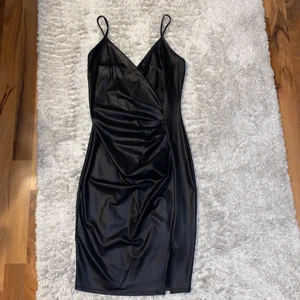Läderklänning i svart strl S - • Klänning i fakeläder. Längd: lite över knäna. Använd 1 gång. Köpt från FashionNova • 