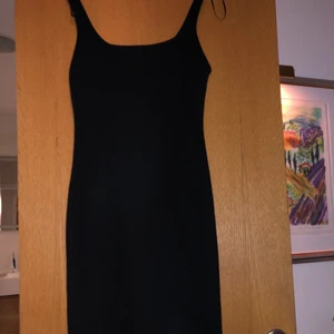 Svart, tight klänning - Klänning från zara trafaluc. Den är för liten för mig att få på mig, så skulle säga att den passar på någon som brukar ha storlek xs eller på gränsen till S. Den går till knäna på mig som är 169. På baksidan har den en liten slits.