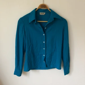 Skjorta i ull - Turkos skjorta i ull. Köpt vintage i Italien. Väldigt skön på hösten och vintern pga värmer. Står att det är en storlek 34 men passar mig som brukar ha 36. 