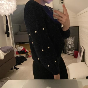 stickad tröja med pärlor - stickad tröja i riktigt mörk blå (nästan svart) med pärlor på armarna, superfint skick och ingen pärla har lossnat, säljes pga för kort i armarna storlek XS (pris 100kr inklusive frakt i spårbart paket) köpt för 399kr