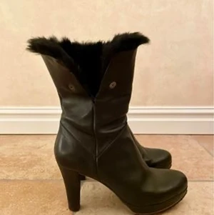 Designer stövletter i skinn med päls - Stövletter i härligt skinn, svarta med päls som går att vika ner, klackhöjd 9cm, platå fram 2 cm. Sköna att gå i. stl 38 i gott skick 