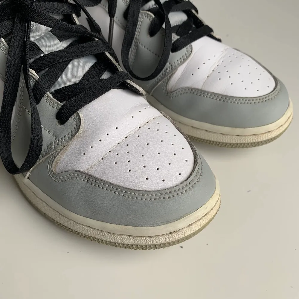 Äkta Air Jordan 1 mid i light smoke grey, köpta på StockX(kvitto finns). Använt men fint skick! Två sömmar på den vänstra plösen har dessvärre gått upp, men det syns ej när skorna är knytna. Skickas i originalkartong. Fraktkostnad tillkommer.. Skor.