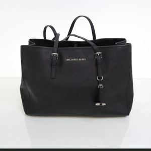 Handväska (Svart) från Micheal Kors - Produktinformation: Varan är i mycket bra skick och nästan som ny. Material: Skinn. Storlek (cm): Bredd 35, Djup 13, Höjd 24. Övrigt: Silverdetaljer. Köpt: Hos Sellpy oktober 2021 (kvitto finns). 