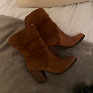 Cowboy boots - Jättefina cowboy boots från Uggs. Köpte för ett par år sen men aldrig använda då dem inte passade, ganska säker på att de är köpta i USA och går inte att få tag på längre. Man kan ha dem på två olika sätt som ni ser på bilderna. Antingen nervikta eller helt uppe. Insidan är som på vanliga uggs väldigt mjuka och fluffiga. Storlek 38! Väldigt fina och i toppskick!