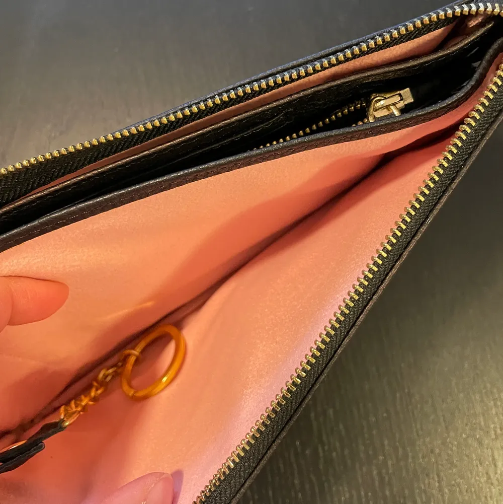 Plånbok från Prada (kopia) i läder. Som man kan använda som plånbok, clinch eller om man sätter fast kedja eller axelrem så blir det en väska. Har flera fack, för kort, nycklar osv. . Väskor.