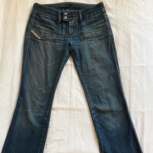Jeans från Diesel - Low-waist Diesel jeans i mörkblå färg💙 Har någon slitning längst ned vid benen och i skrevet men inget som syns! Endast provade✨Skriv för fler bilder.
