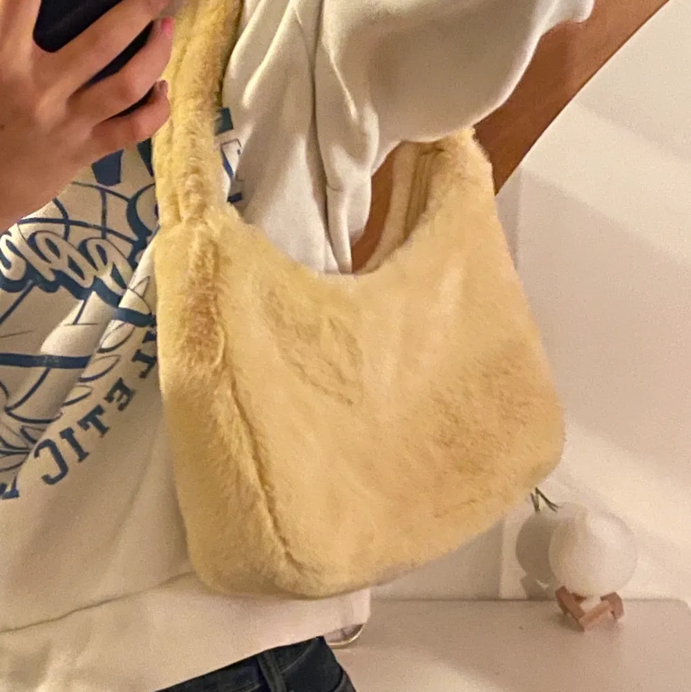 Säljer min gula fluffiga handväska som är perfekt för att kunna liva up outfits med, den är även endast använd 1-2 gånger🥰 väskan är från monki och är även slutsåld. Köpte den för 250kr och  därför är utropspriset 149 kr 💕💕. Väskor.