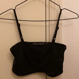 Svart croptop - Svart snygg croptop från Shadows of the mind. Köpt i Sydafrika, använts tre gånger. Köpare står för shipping. 