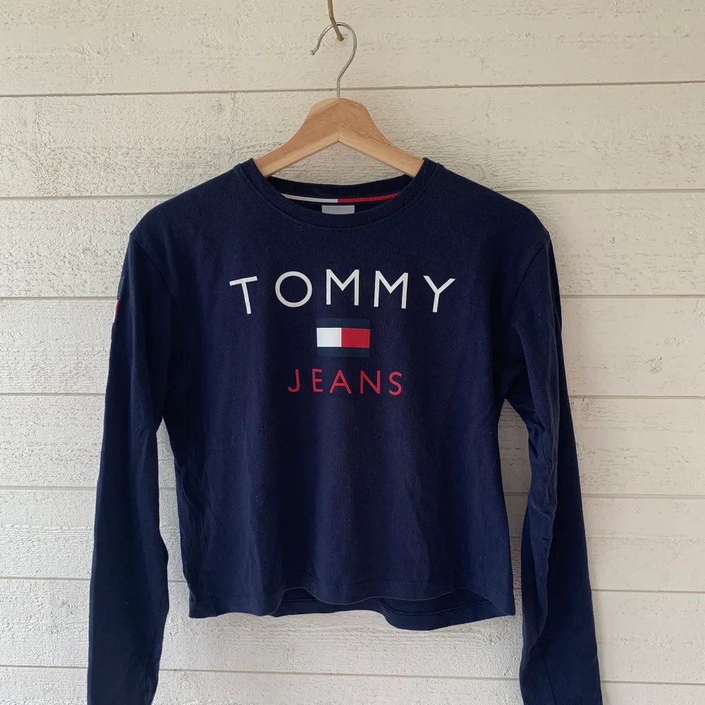 Sweatshirt från Tommy Jeans med tryck på ryggen. Storlek XS, i nyskick! Lite kortare i modellen men långa ärmar. Tröjor & Koftor.