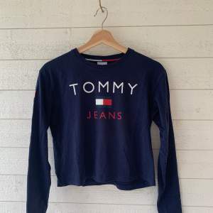 Sweatshirt från Tommy Jeans med tryck på ryggen. Storlek XS, i nyskick! Lite kortare i modellen men långa ärmar
