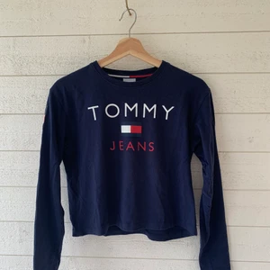 Tommy Hilfiger sweatshirt med tryck - Sweatshirt från Tommy Jeans med tryck på ryggen. Storlek XS, i nyskick! Lite kortare i modellen men långa ärmar