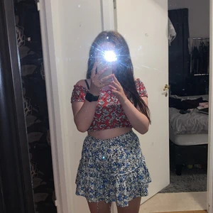 Ginatricot  - En rött kort tröja men vita blommor på