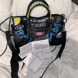 Balenciaga graffiti city bag  - Säljer min ursnygga balenciaga väska!! Nypris cirka 15k, äktenskapsbevis följer med och skriv för fler bilder eller frågor. Längd 16cm, Bredd 34cm, Djup 6cm❤️ gratis frakt. Budgivning fram till 22a eller köpa direkt för 5800kr.