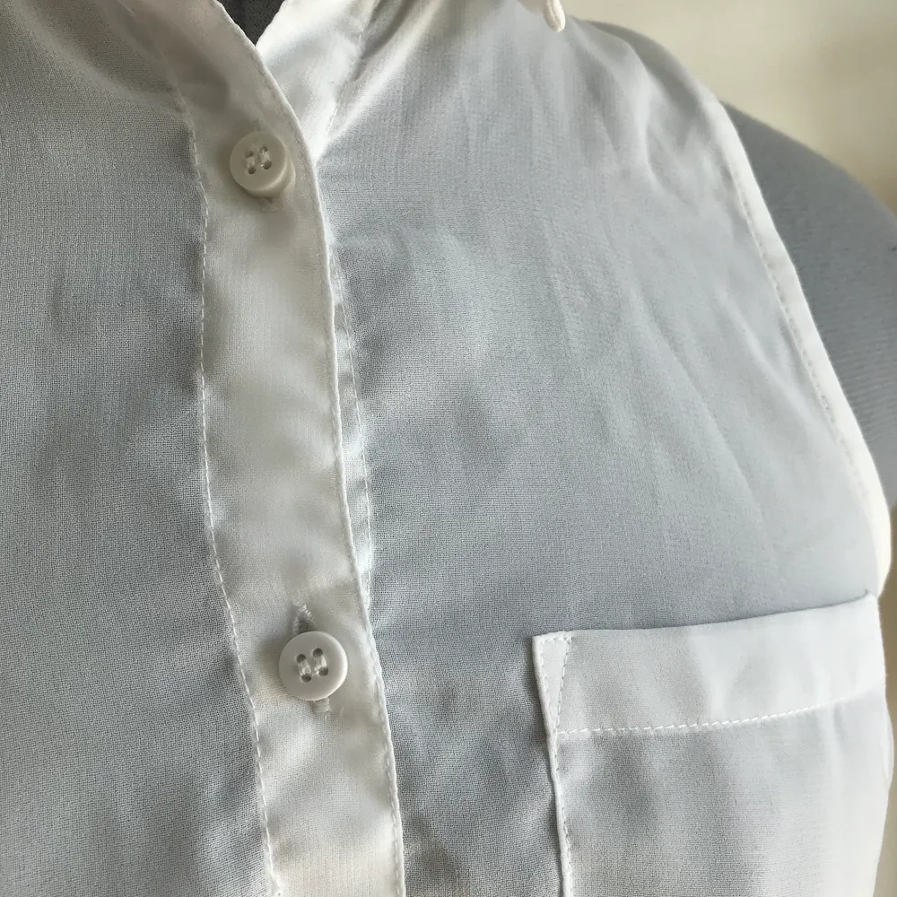En sval ärmlös skjorta i genomskinligt vitt tyg. Står att det är XXS men jag tycker den är som XS. . Blusar.