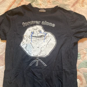 Svart t-shirt - En svart t-shirt som sitter tight och riktigt skön, 100% bomull. Lite roligt tryck men aldrig hittat användning för den.