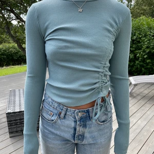 Ljusblå topp med detlaj - Ljusblå ribbad topp med dragsko detalj från Nakd som aldrig kommit till användning hos mig... Nypris 299kr