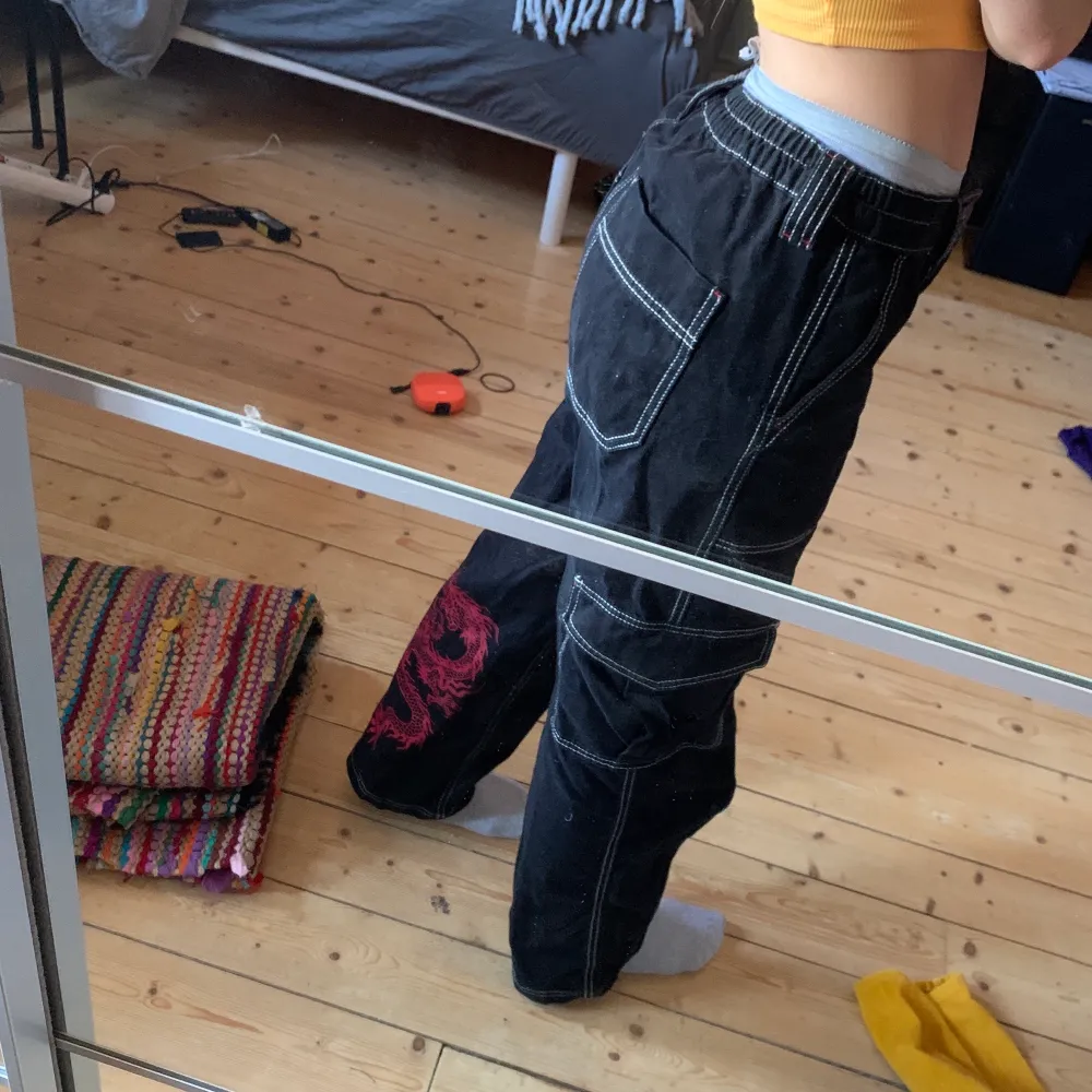 Säljer mina knappt använda byxor från urban outfitters! Dessa är supercoola och har en röd drake på baksida vad, samt röda detaljer! jag är 171 cm🥰. Jeans & Byxor.