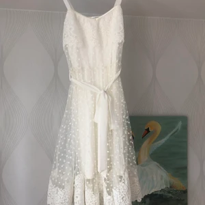 Ida Sjöstedt klänning Melodie - Superfin, somrig klänning från Ida Sjöstedt, som inte är använd mer än en gång, så verkligen som ny! Den är inte tvådelad, men den består som av en överkjol i tyll och spets nedtill och en underklänning. Storlek Small. Obs, Bilden i mitten är bara till för visa passformen. Den klänning jag har prickigt mönster som visas på de andra bilderna. Klänningen är också lite kortare än klänningen som modellen har på sig.  Nypris 2499