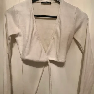 Vit topp - Jättefin topp som både kan användas som en tröja eller en kofta. Endast använd en gång. Skriv privat till mig ifall du vill ha fler bilder eller se plagget på. Kunden står för frakten. 