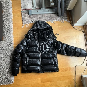Crvdae black puffer jacket - Crvdae black puffer jacket, sold out and never being restocked in this colourway.  Size s  Arms and hood and chest logo is detachable.   Lenght: 63.0 cm Shoulder: 48.5 cm Chest: 58.0 cm Sleeve: 67.0 cm