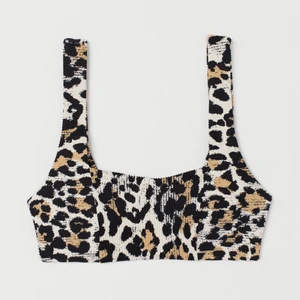 POPULÄR BIKINI I LEOPARD IFRÅN HM TVÅDEL - En fodrad, bygellös bikinitopp. Toppen har kupor med uttagbara inlägg som formar bysten och ger bra stöd. Breda axelband. Helfodrade bikinitrosor. Trosorna är medeltäckande bak. Normalhög midja. Aldrig använda! Nypris 199:- (bikinitopp), 99:- (bikinitror). KompositionYtterlager: Polyamid 90%, Elastan 10%Foder: Polyester 88%, Elastan 12%