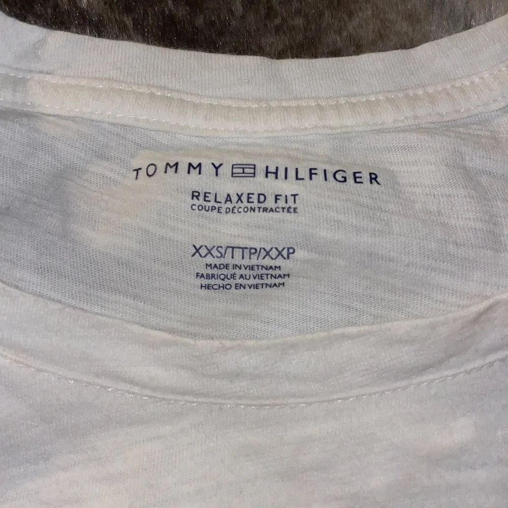 Vit tröja från Tommy Hilfiger, sänkt pris pga liten fläck på axeln, se bild. . T-shirts.