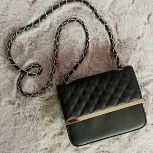 Axelväska - En svart crossbody väska i bra skick ifrån Nelly. Silvriga detaljer.