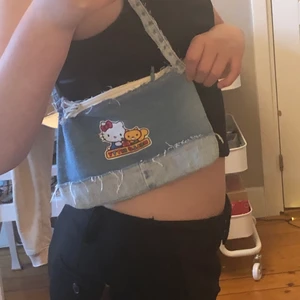 Väska - Väska som jag har sytt själv, därför är dragkedjan inte så bra. Väskan har ett hello Kitty tryck på den.