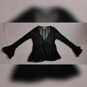 Svart topp i spets - Boho-topp i babydoll-skärning som andas 70-tal. Svart spets med mycket fina detaljer i tyget såsom pärlor, paljetter, och olika sorters spets. Vida ärmar och flexibel i storleken, gissningsvis cirka S-M, möjligtvis liten L.   Avhämtning i Stockholm eller skickas mot frakt.