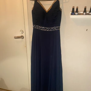 Balklänning från JJC House - Använd en gång, marinblå med strass, den går ända ner till marken, även för mig som är 168 kan ha ca 8 cm klackar och änfå går den hela vägen ner! Ordinare pris 1400