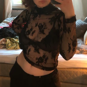 Svart topp med blommor - Svart topp med blommönster och polokrage. Så gått som ny! Frakt tillkommer i priset🌞