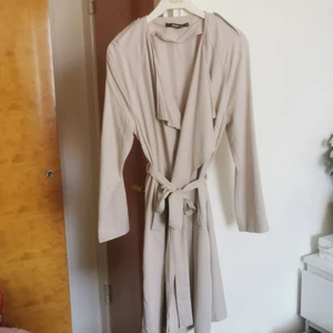 Trenchcoat - Snygg tunn trenchcoat från gina. Kan säkert användas som klänning också. Sparsamt använd. Frakt ingår i priset. 