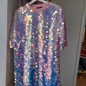 Klänning med paljetter - Rosa klänning med stora paljetter och rak passform. Den har tappat några få paljetter men det är inget man tänker på.