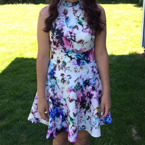 Blommig klänning - Blommig klänning i härliga färger och stretchigt tyg. Ringningen består av en liten polo och ryggen är öppen (se sista bilden). Kan mötas upp i Göteborg/Nyköping alternativt skicka om kund står för frakt 🌼