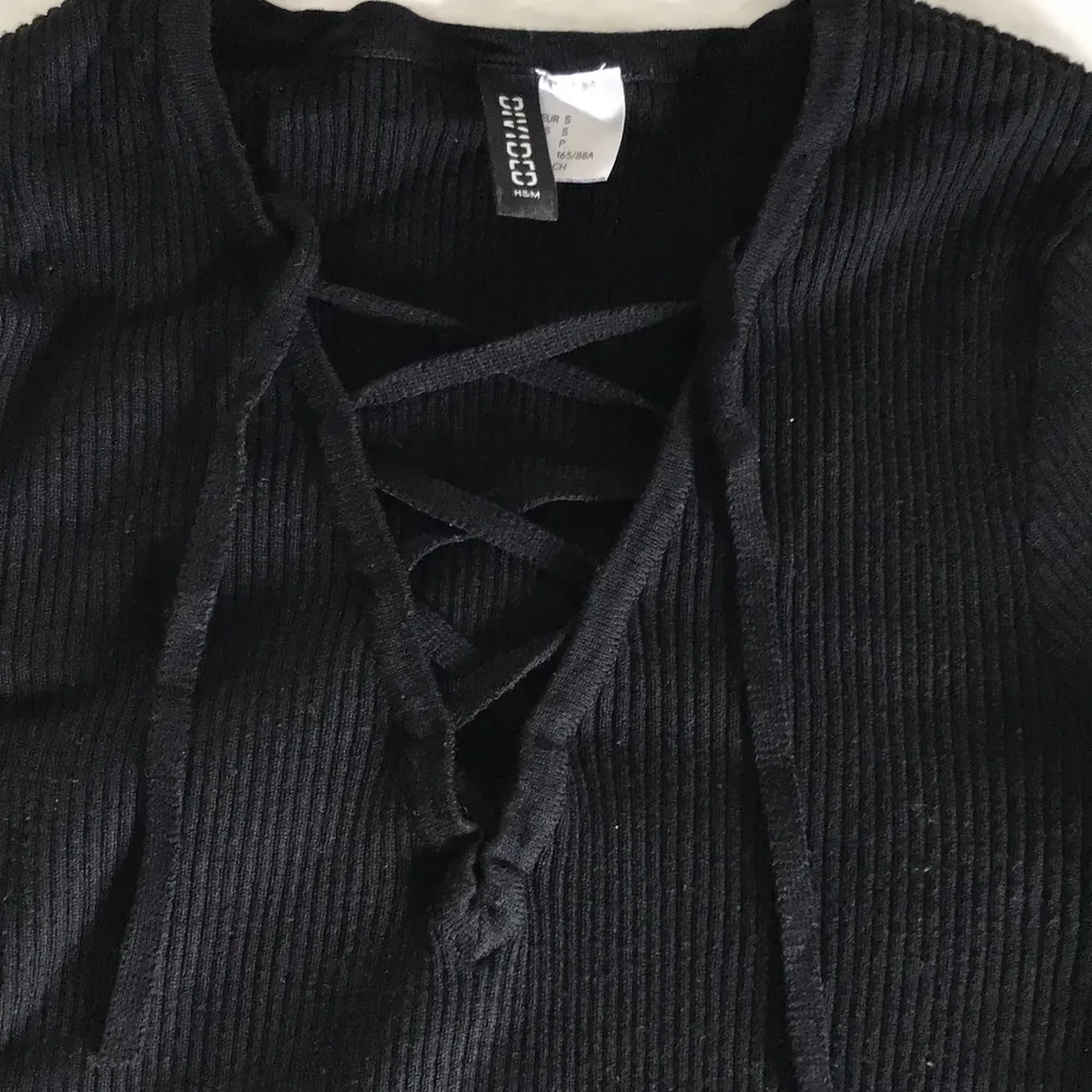 Väldigt fin långarmad svart ribbad tröja med snörning! Jättebra skick! Säljer den eftersom den sällan kommer till användning. Från HM i storlek S, men passar också XS! Köparen står för frakten.. Tröjor & Koftor.