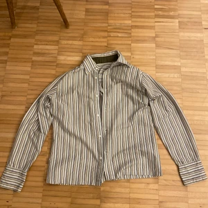 Randig skjorta  - Jag säljer en randig skjorta i oanvänt skick. Möts upp i innerstan, alternativt att jag fraktar.