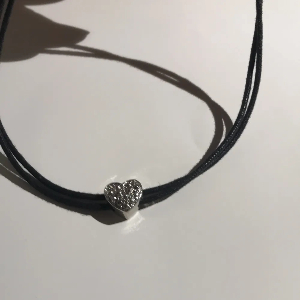 Halsband svart med ett silver hjärta gullit :)). Accessoarer.