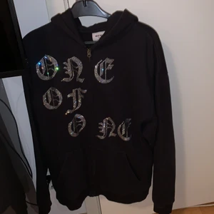One Of One zip svart - Säljer denna då jag inte änvänder den mer. Använd några gånger. Skick 9/10, alla rhinestones sitter kvar. Storlek Large men passar Medium. Bud från 1050kr