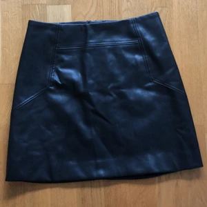 Skinnkjol  - Säljer denna skinnkjol från H&M. Har endast använts fåtal gånger så är i bra skick. (40cm lång, knapp och dragkedja i ryggen)